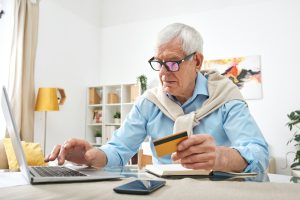 Modern elderly man buying online